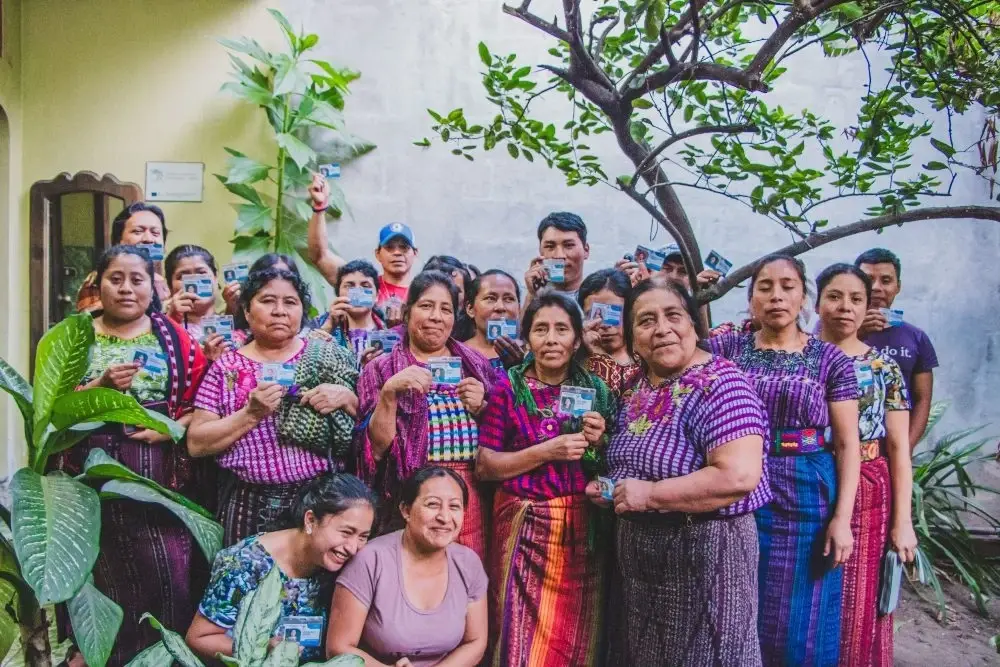 Mujeres guatemaltecas sostienen sus tarjetas de salud