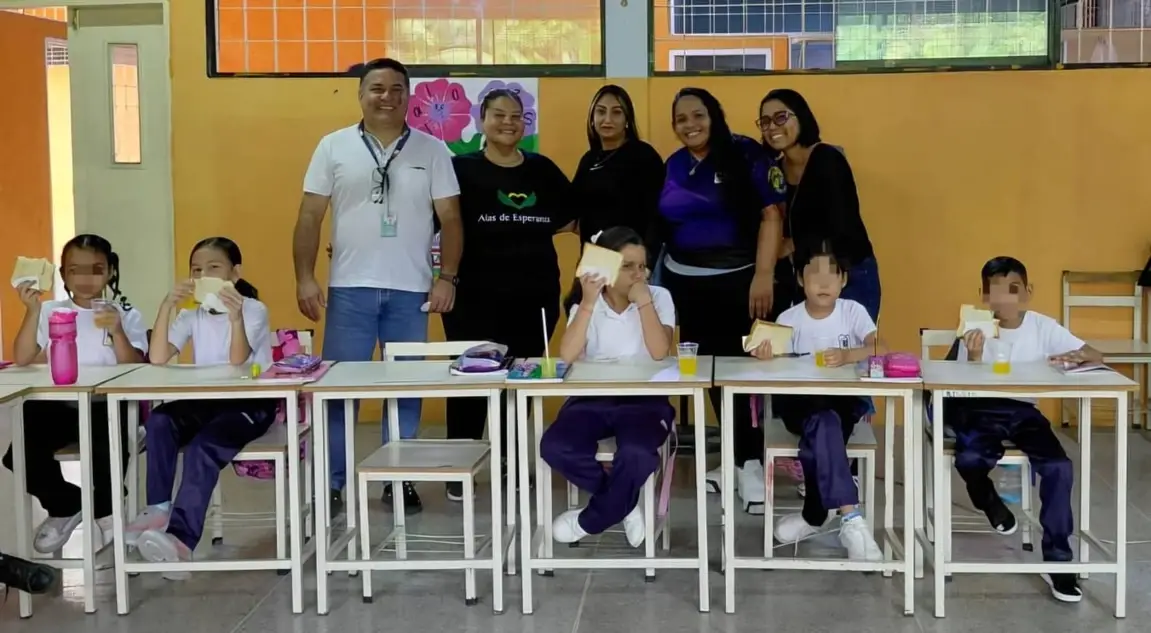 Niños y niñas posando mientras comen su refrigerio
