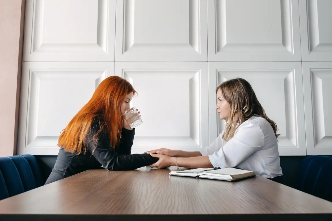 Two young women discussing a serious topic.
