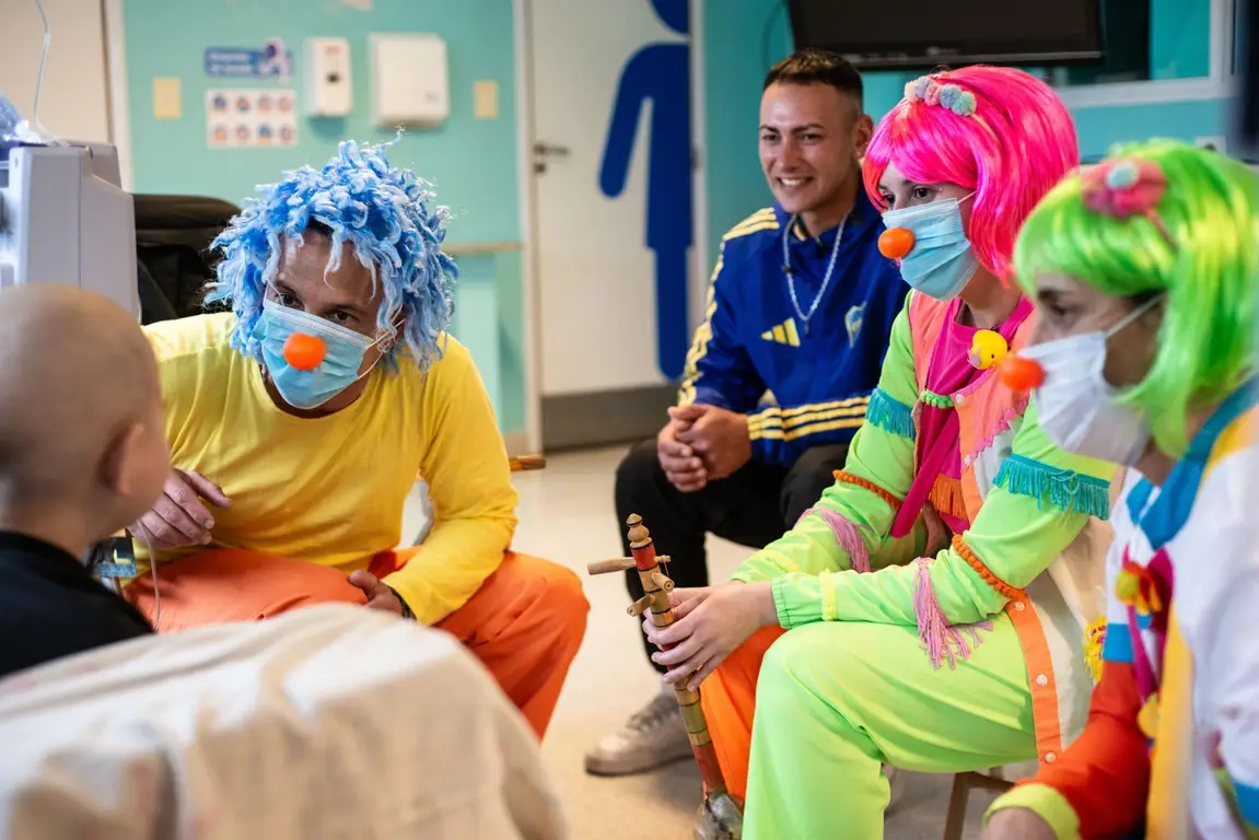 Un grupo de personas con ropa de payasos visitan un hospital