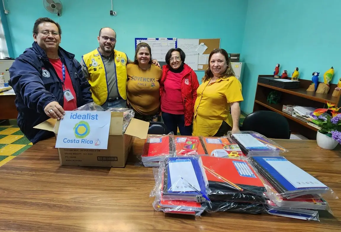 Personas sostienen el logo de Idealist durante una donación