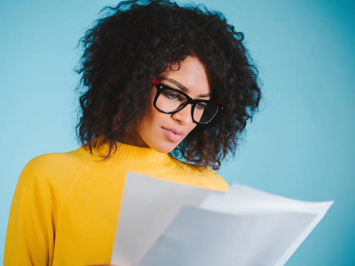 A young woman looking at a few sheets of paper