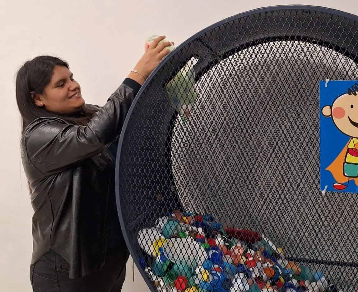 Mujer depositando tapitas en un contenedor