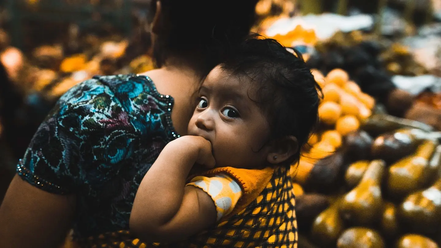 A woman carrying a baby.