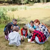 Group volunteers with kids to identify native insects at a wildlife center in the United States.