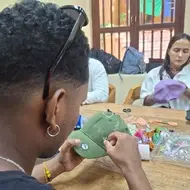 Participante bordando una gorra durante la iniciativa “Manos que transforman” en Colombia.