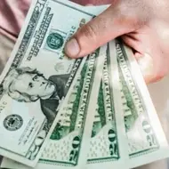 A close up of a person holding money for the blog post, When Should You Take a Pay Cut?