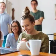 Grupo de personas reunidas mirando juntas la pantalla de una laptop