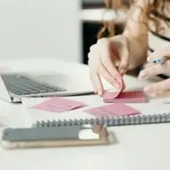 Mujer tomando notas en post its de colores