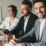 man smiles in board meeting at office