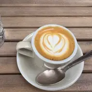 Taza con un café cortado y un vaso de agua