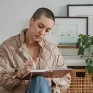 Mulher escrevendo anotações em um caderno