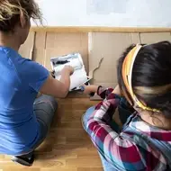 Women volunteer to paint a habitat for humanity home.