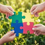 4 hands each holding puzzle pieces put together