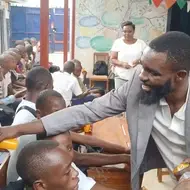 Thierry N. from Burundi passes out porridge to children at a local school.