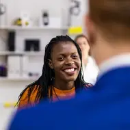 Two people smile while networking at work