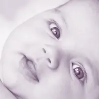 A baby lies on a soft blanket.