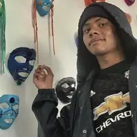Student in front of paper mache masks