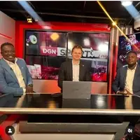 James, a journalism intern from Oxford University, Edinburgh, pictured with a sports analyst at Guide TV in Accra, Ghana. During his four-week internship with Pro-Passion Projects, James volunteered across The Daily Guide’s newspaper, radio, and television platforms, gaining hands-on experience in journalism. In this image, he joins top Ghanaian sports journalists on a live TV panel, actively participating in discussions on sports analysis, reporting, and media ethics. The studio environment shows cameras, microphones, and monitors in the background, with production staff supporting the broadcast. James is engaged and professional, interacting confidently with the panelists, reflecting his learning and contribution as an international journalism volunteer. This experience highlights the collaboration between global interns and local media professionals to strengthen practical journalism skills and media exposure