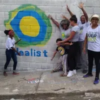 Turma de pessoas mostra o símbolo do idealist pintado na parede