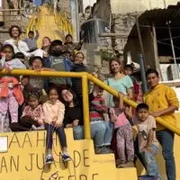 Children and volunteers in group on the stairs near the classroom