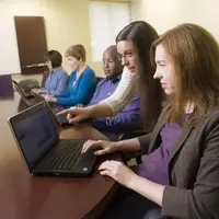 Librarian assisting customer on laptop