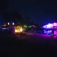 Outdoor space lit up with coloured fairy lights and a fireplace