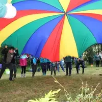 Young people and leaders playing with parachute