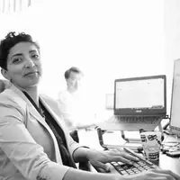 Haifa working on a user stories collection at her desk.