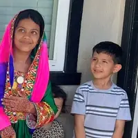 three children, one in traditional Afghan dress