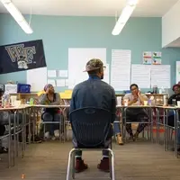 Room of Black women considering an idea. Room is covered with chart paper with notes.