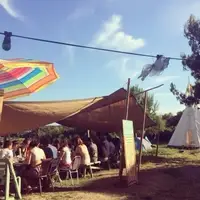 Group of people at a long table outdoors.