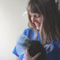 woman holding kitten in a cone