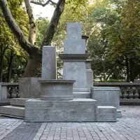 A series of gray concrete plinths of varying shapes and sizes, stacked upon each other in a pile