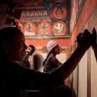 back lit woman painting in a Tibetan Buddhist monastery
