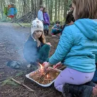 students making fire in foil pan to practice fire structures