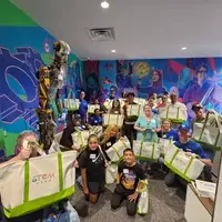 Group of volunteers holding the Tinker Totes they put together.