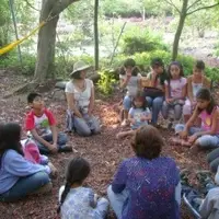 Niños sentados en círculo junto a sus profesoras