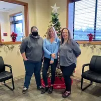 Training dept. staff are standing in front of a Christmas tree.