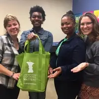 Cooking Matters volunteers and program staff show off our take-home grocery bags for participants.