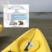 Sea Otter Savvy informational card on a kayak at a coastal launch site