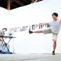 a modern dancer and musician performing in front of a photography exhibition