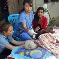 Volunteer Doctor helps a patient on bed