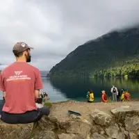 MNR student sitting on edge of water front.