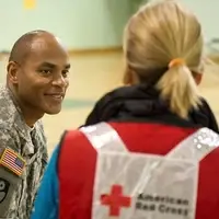 A Red Cross Volunteer works with a US service member in a shelter