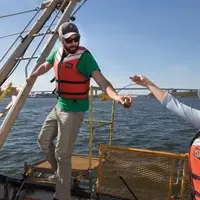 Students passing research instrument boat.