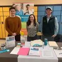 Staff are posing for a photo at a career fair.