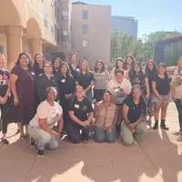 Group photo of about 20 diverse girls, gender-expansive youth, and women standing outside on a sunny balcony at an Alliance for Girls event in San Jose.