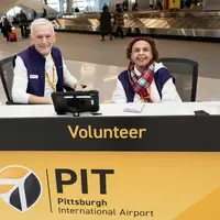 A man and a woman sitting at PIT volunteer Information Desk