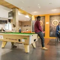 Students chatting by a pool table in a college social space
